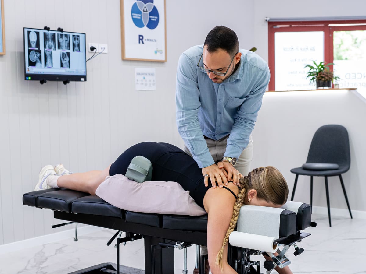 Dr Josh adjusting a patient lying on a pregnancy pillow on the chiropractic table